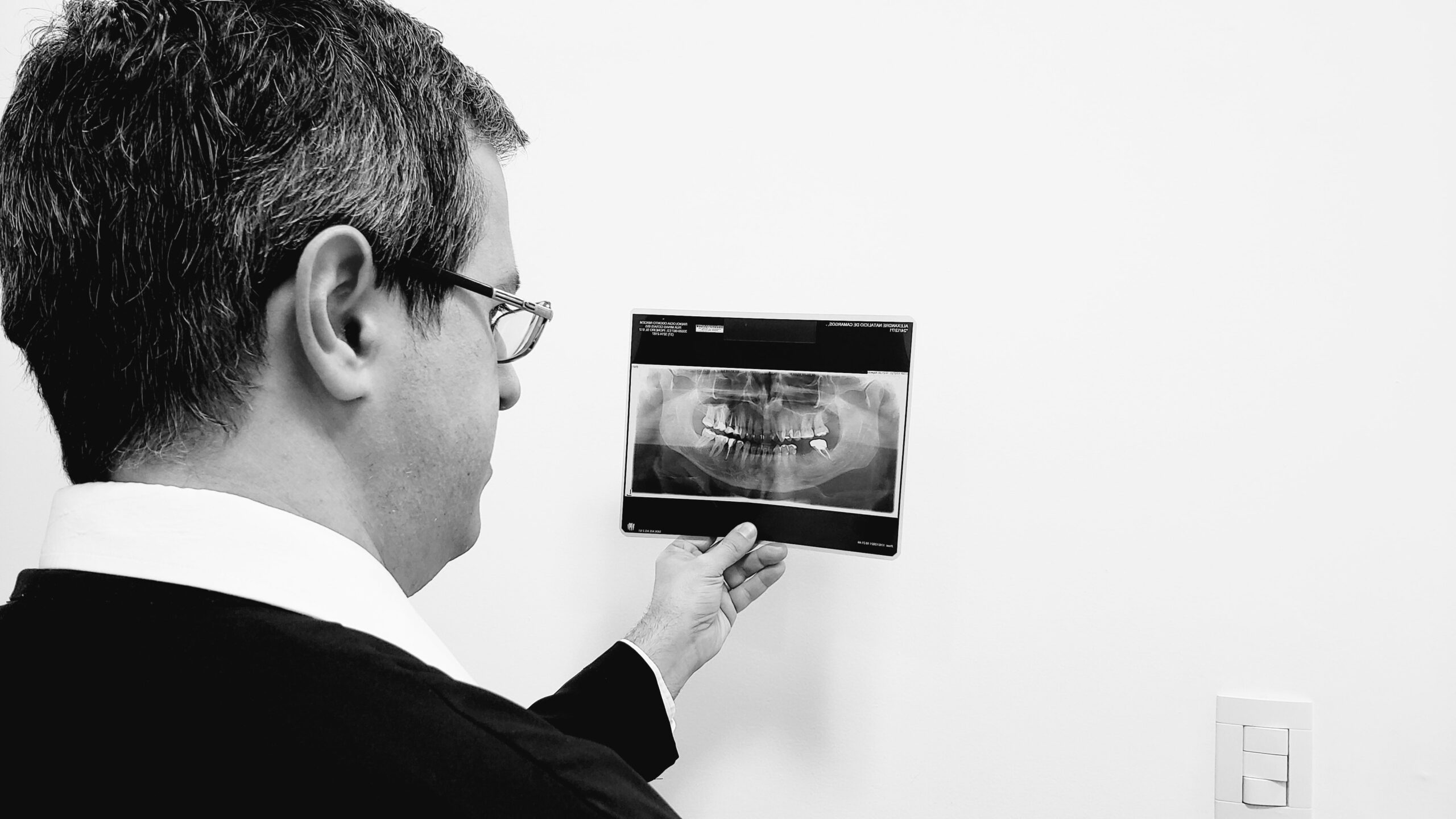 Dr. Luís Morato analisando radiografia — dentista urgência Divinópolis