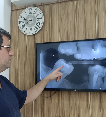 Dr. Luis Morato explicando raio-X digital ao paciente em Divinópolis